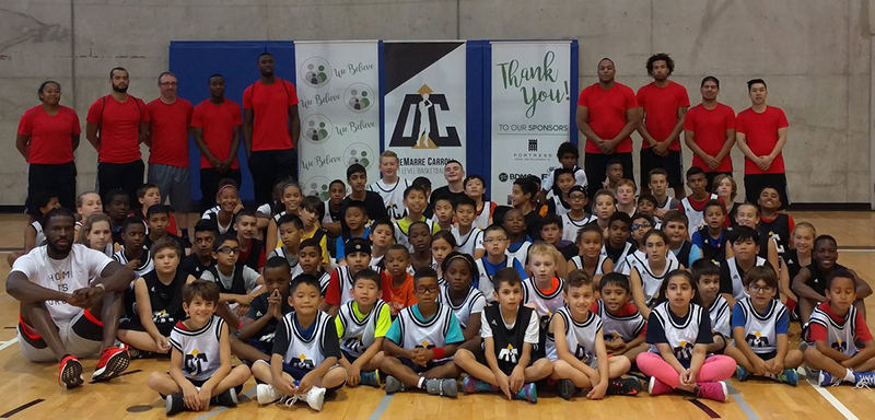 DeMarre Carroll representing the participating kids wearing custom t-shirts and custom jerseys at the basketball camp.