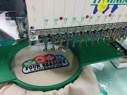 Custom embroidery machine printing client order on embroidered custom shirts.