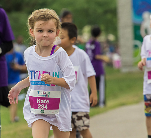 Kids running at the Tri-FUN marathon wearing custom printed t-shirts.