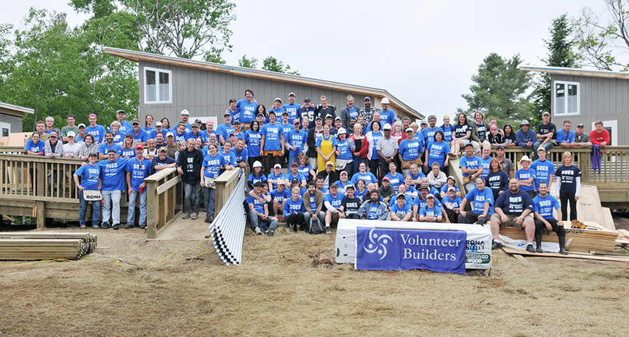 Volunteer builders wearing custom t-shirt with their design at the charity gathering.