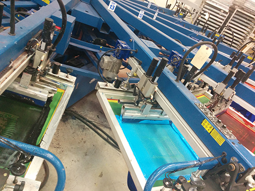 Automatic screen-printing machines running a custom t-shirt order.