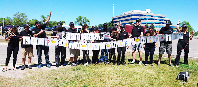 Budd's Cadillac employees do a team challenge wearing black custom t-shirts and custom embroidered hats.