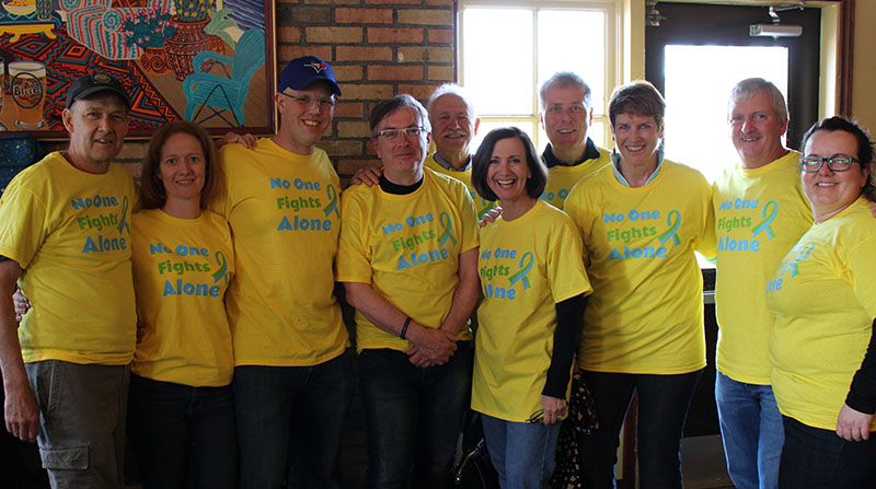 Group of people wearing bright yellow charity custom printed t-shirts.