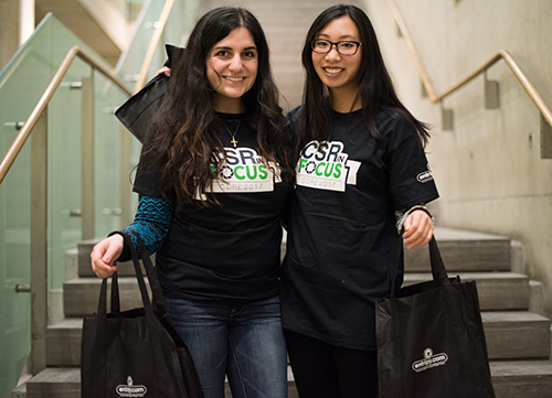 Participants at a charity event wearing custom t-shirts and holding promo giveaways of custom tote bags.