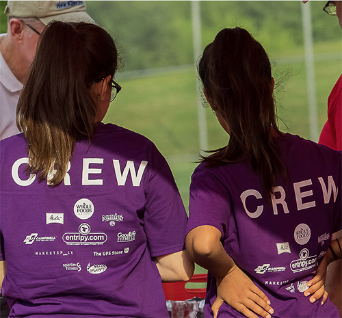 Volunteers helping at a not-for-profit event for children wearing personalized shirts.