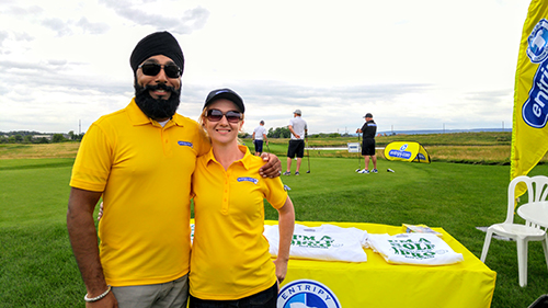 Entripy employees wearing yellow custom golf shirts for personalized uniforms at an event.