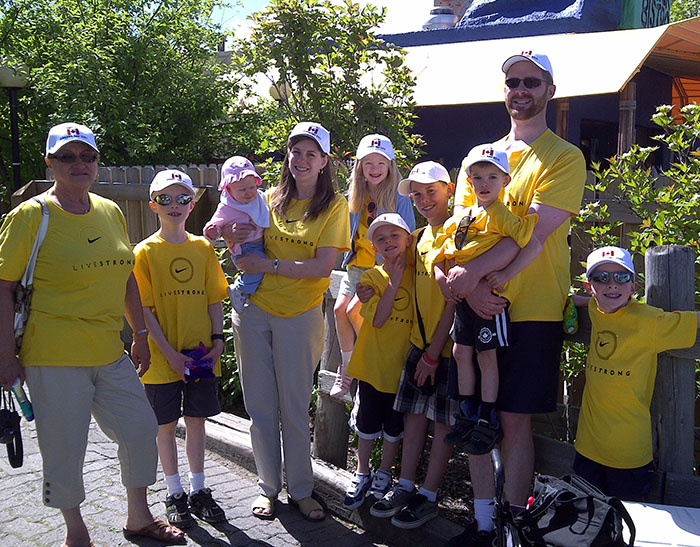 Family members at a family reunion display customized t-shirts and embroidered hats.