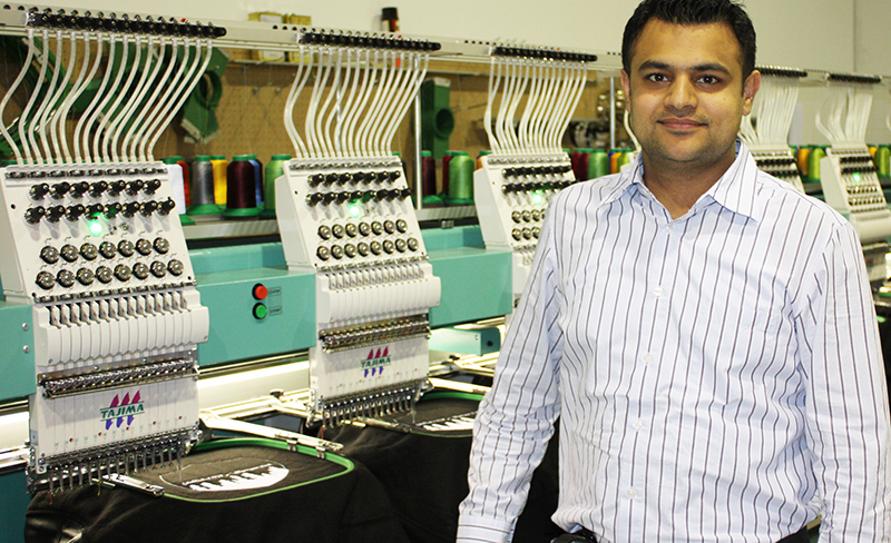 Entripy's CEO, Jas Brar, showcasing the embroidered machines used for custom clothing.