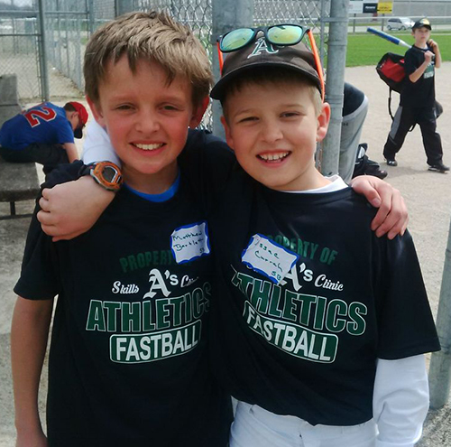 Youth sports players in their custom baseball t-shirt and custom cap representing their team.