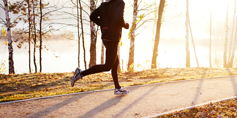 Active individual wearing athletic wear including custom jacket is jogging.