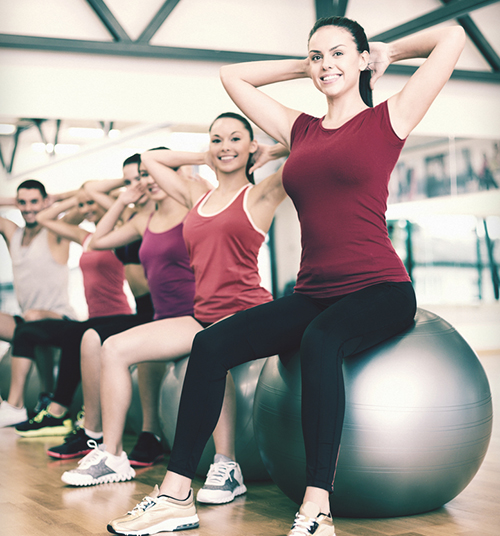 A gym class doing exercise wearing athletic wear and have the option to custom print t-shirts with logo.