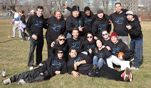 Entripy clients displaying their custom hooded sweatshirts, embroidered toques and customized caps at an outdoor event.