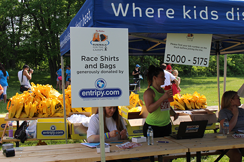 custom promo giveaways displayed at a charity event including custom tote bags and printed t-shirts.