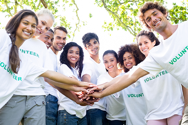 Group of people wearing white custom t-shirts with custom design text of Volunteer on the front.