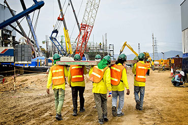 Construction employees working wearing custom high visibility vests.