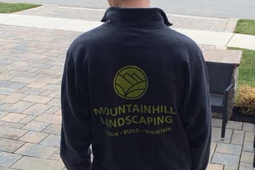 Landscaping worker outside wearing custom high-visibility vest.